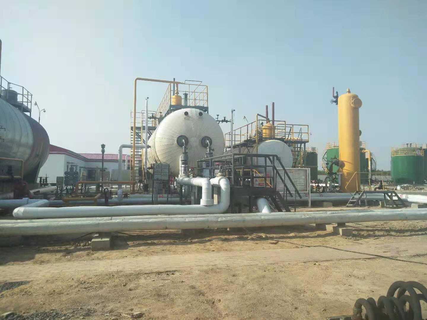 Vacuum phase-change heater serving a multi-well production system