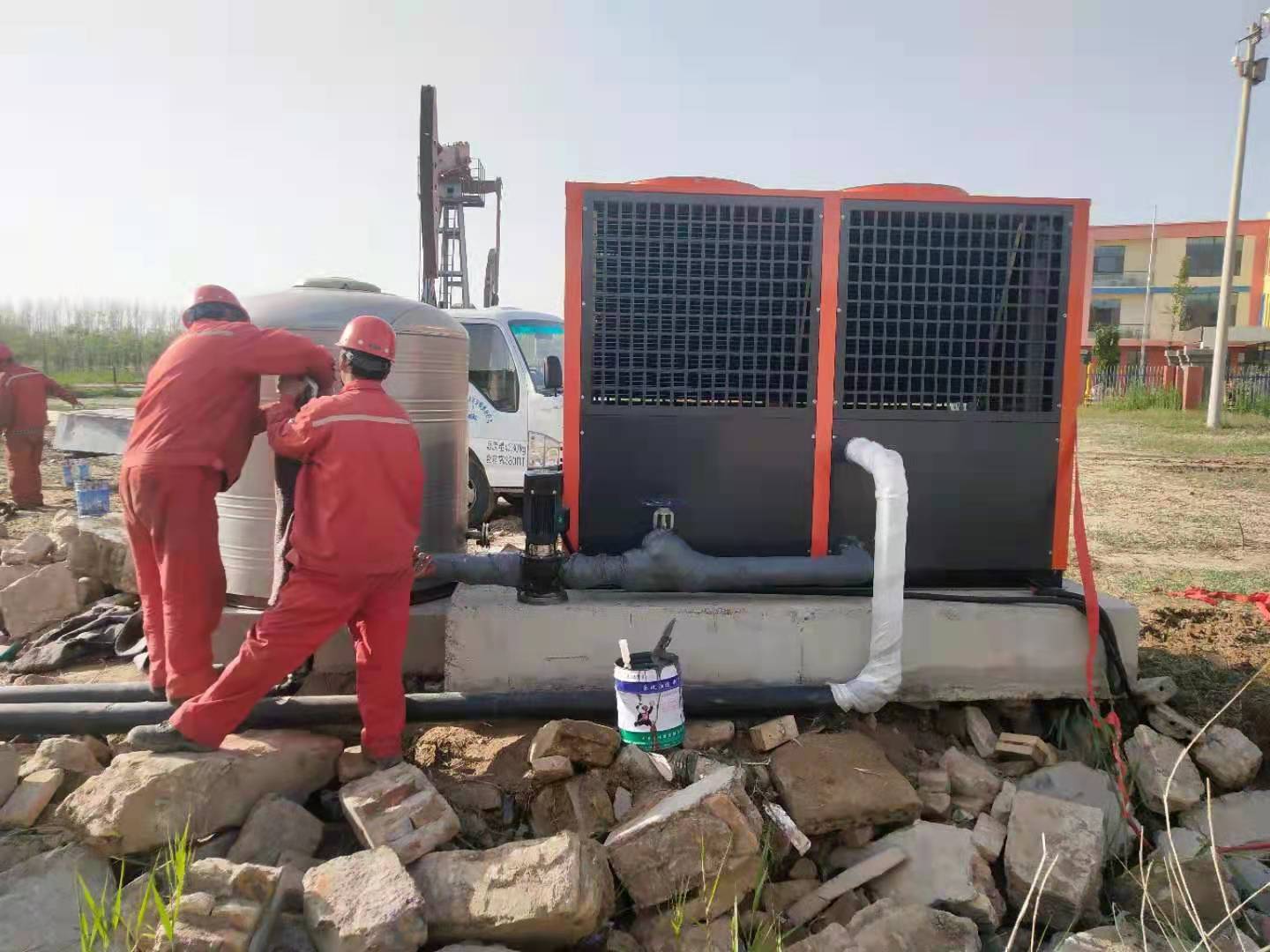 Split-body vacuum phase-change heater being installed in a compact wellpad
